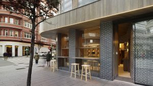 Fachada a Juan Flórez con barras de degustación y 2ª entrada en diseño interior de Panadería Carnoedo