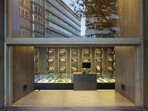 Barra de degustación desplegada con enchufes para móviles y portátiles en diseño interior de Panadería Carnoedo