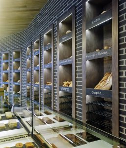 Detalle exposición retroiluminada y rótulos caligrafiados a mano en diseño interior de Panadería Carnoedo