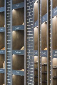 Detalle exposición retroiluminada y rótulos caligrafiados a mano en diseño interior de Panadería Carnoedo