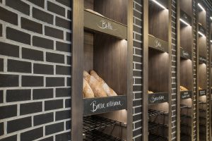 Detalle exposición retroiluminada y rótulos caligrafiados a mano en diseño interior de Panadería Carnoedo