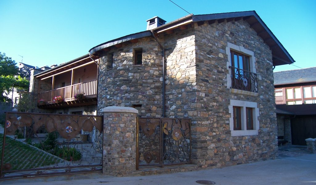 Fachada, torreón y balconada en casa unifamiliar de piedra