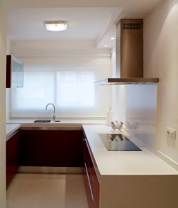 Diseño interior de piso en Galicia. Mesado de trabajo, vitrocerámica y fregadero al fondo