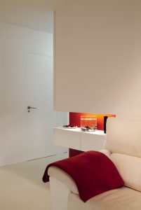 Diseño interior de piso en Galicia. Espacio decorativo y puerta baño al fondo. Interesante la forma de integrar las puertas, sin guarnición y totalmente enrasadas con el paño del pasillo