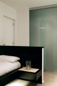 Diseño interior de piso en Galicia. Cama habitación con baño al fondo