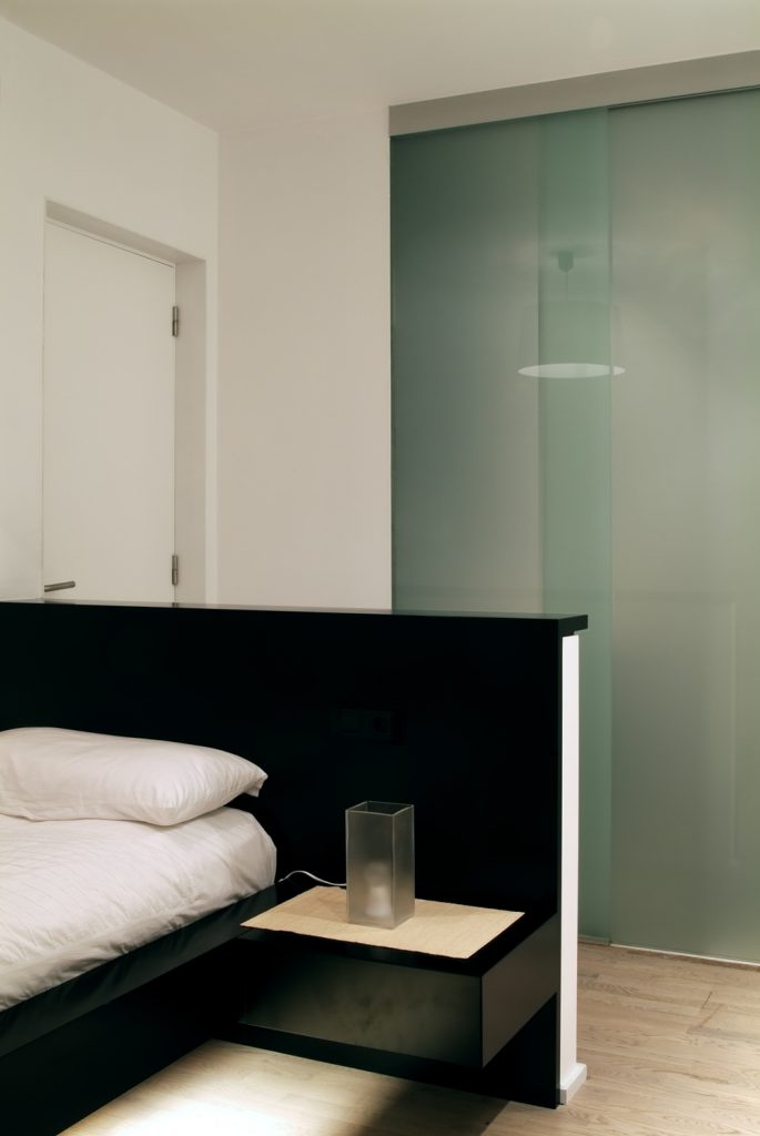 Diseño interior de piso en Galicia. Cama habitación con baño al fondo