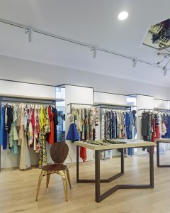 Iluminación y cuelgue de prendas en diseño interior de tienda de moda de mujer Jonathans