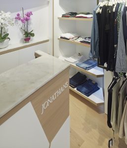 Mostrador de venta. Detalle sobre en mármol y logotipo en relieve en diseño interior de tienda de moda de mujer Jonathans