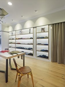 Vista lateral de la tienda, exposición y probadores en diseño interior de tienda de moda de mujer Jonathans