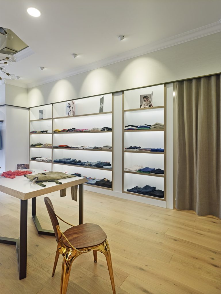 Vista lateral de la tienda, exposición y probadores en diseño interior de tienda de moda de mujer Jonathans