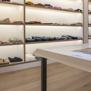 Detalles en canto de mesas de atención personalizada en diseño interior de tienda de moda de mujer Jonathans