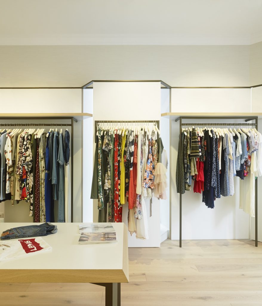 Exposición-cuelgue. Detalle acceso (cerrado) a escaparates en diseño interior de tienda de moda de mujer Jonathans