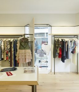 Exposición-cuelgue. Detalle acceso (abierto) a escaparates en diseño interior de tienda de moda de mujer Jonathans