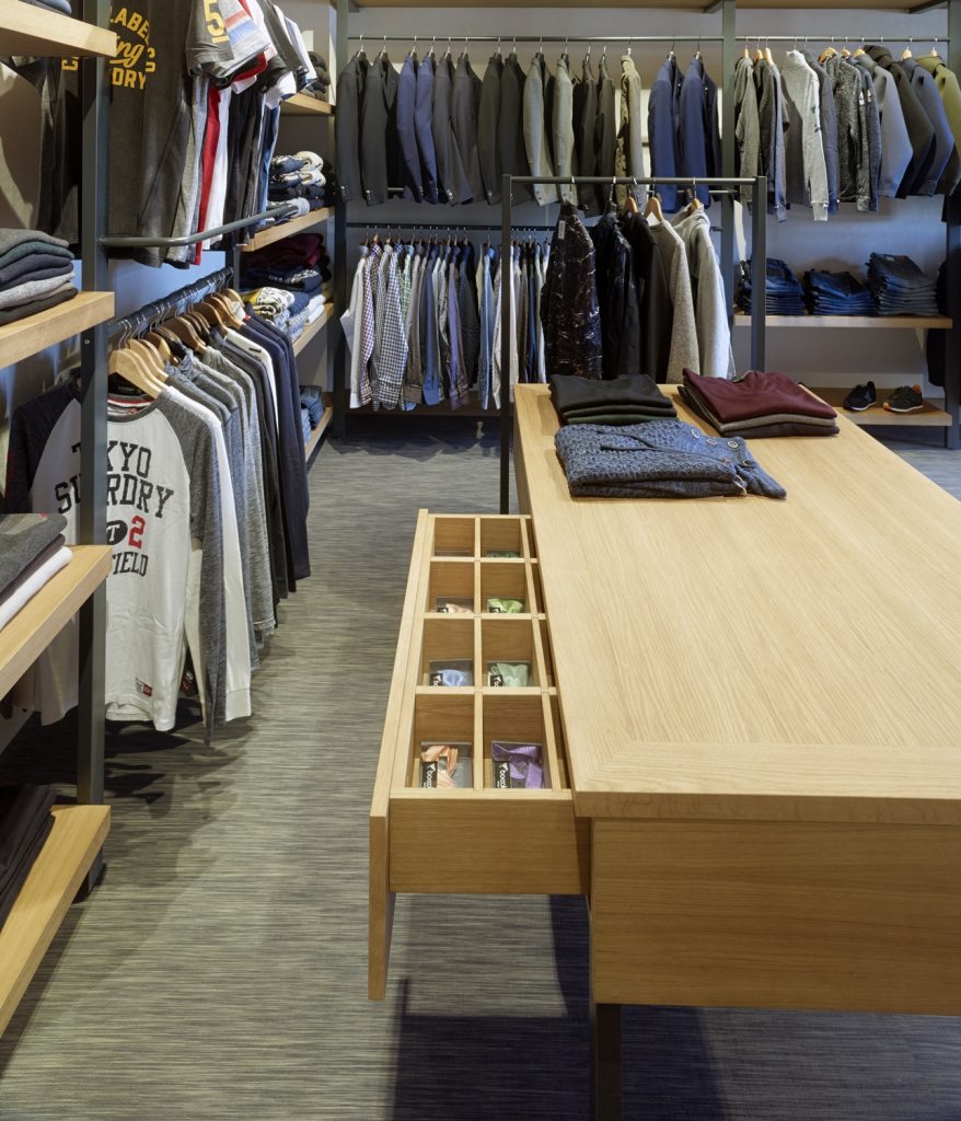 Detalle expositor de complementos integrado en mesa de atención personalizada