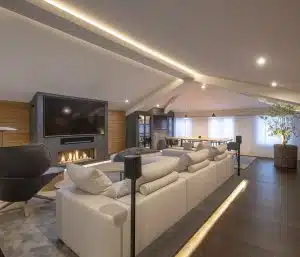 Sofá Groundpiece de Flexform, butaca Tabano de B&B Italia, altavoces Sonos One y TV 82". Diseño y equipamiento vivienda en la costa