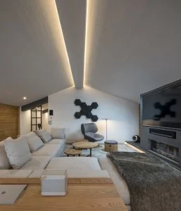 Sofá Groundpiece de Flexform, butaca Tabano de B&B Italia, equipo hifi Beosound Shape de Bang & Olufsen y altavoces satélites Sonos One. Diseño y equipamiento vivienda en la costa