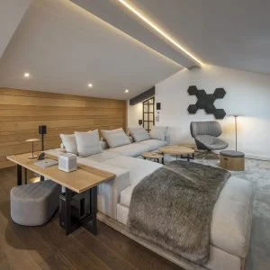 Sofá Groundpiece de Flexform, butaca Tabano de B&B Italia, equipo hifi Beosound Shape de Bang & Olufsen y altavoces satélites Sonos One. Diseño y equipamiento vivienda en la costa