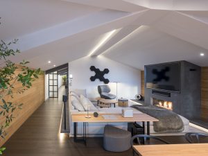 Sofá Groundpiece de Flexform, butaca Tabano de B&B Italia, altavoces Sonos One y TV 82". Diseño y equipamiento vivienda en la costa