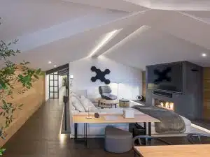 Sofá Groundpiece de Flexform, butaca Tabano de B&B Italia, altavoces Sonos One y TV 82". Diseño y equipamiento vivienda en la costa